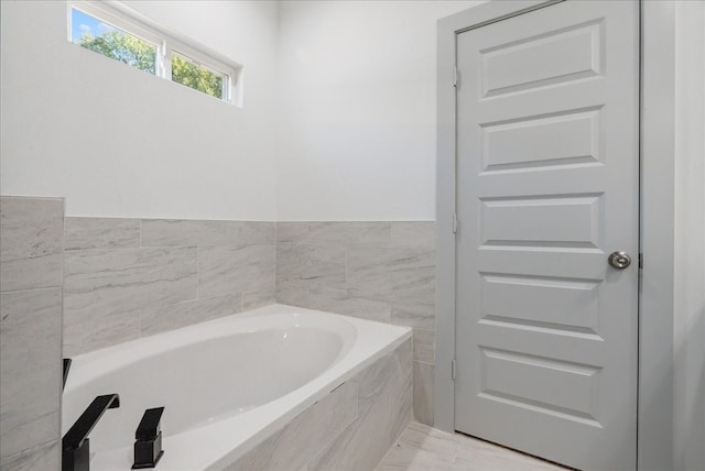 bathroom featuring tiled tub