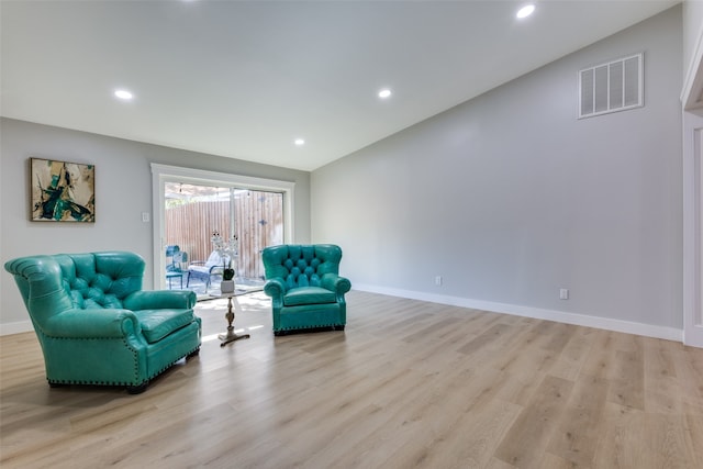 living area with light wood-type flooring and lofted ceiling