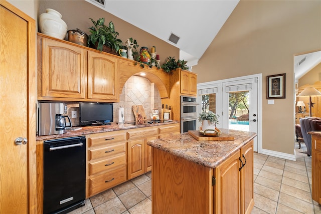 kitchen featuring light tile patterned floors, tasteful backsplash, a kitchen island, double oven, and light stone countertops