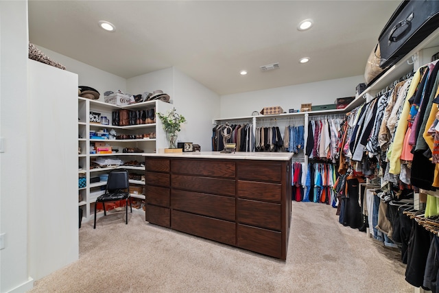 walk in closet with light colored carpet