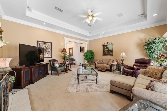 carpeted living room featuring ceiling fan, crown molding, and a tray ceiling