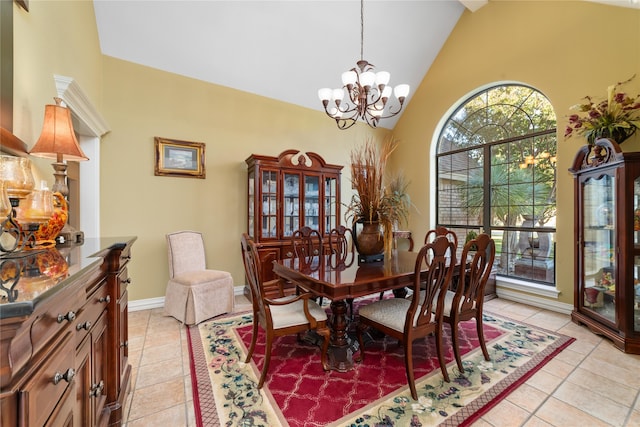 tiled dining area with high vaulted ceiling and an inviting chandelier