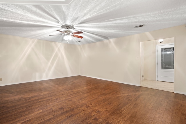 empty room featuring wood-type flooring, ceiling fan, and a textured ceiling