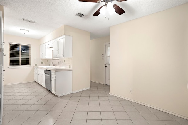 kitchen with white cabinetry, stainless steel dishwasher, decorative backsplash, and a textured ceiling