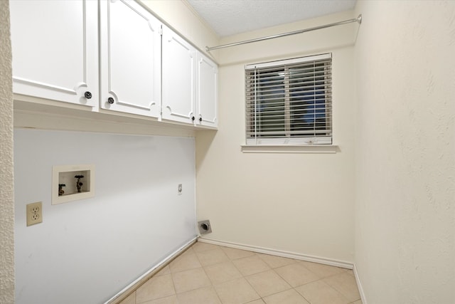 washroom featuring hookup for an electric dryer, a textured ceiling, hookup for a washing machine, and cabinets