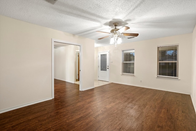 spare room with dark wood-type flooring, ceiling fan, and a textured ceiling