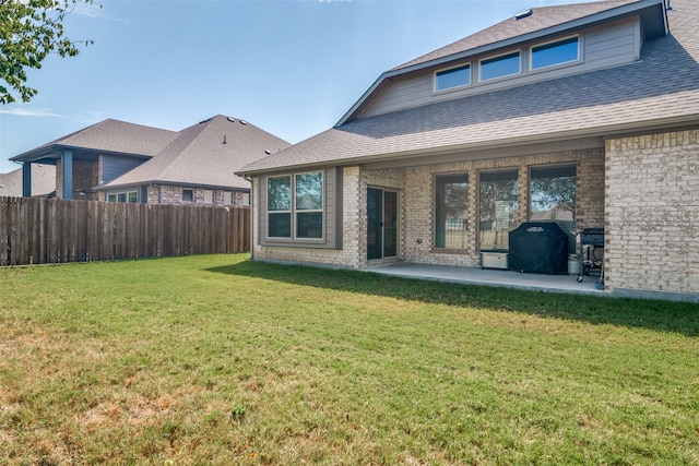 rear view of property with a patio and a lawn