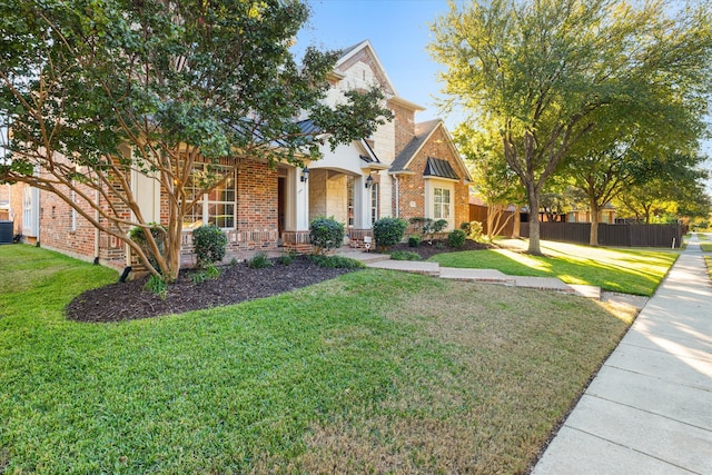 view of front of home with central air condition unit, a porch, and a front yard