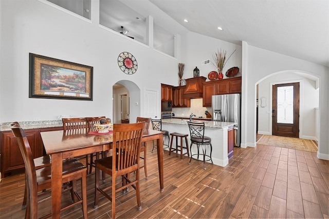 dining area featuring dark hardwood / wood-style floors and high vaulted ceiling