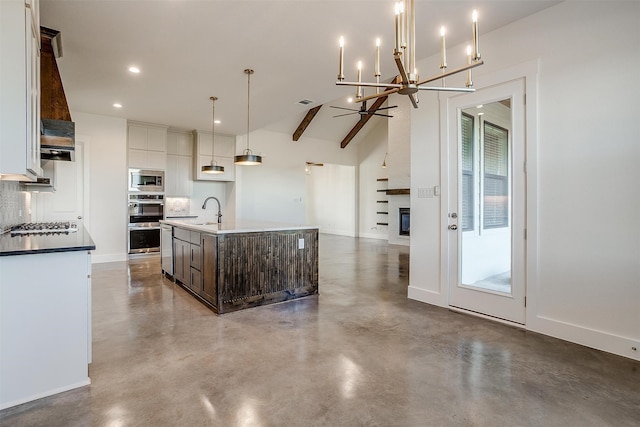 kitchen featuring sink, dark brown cabinets, appliances with stainless steel finishes, an island with sink, and pendant lighting