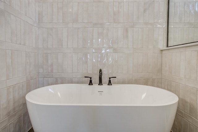 bathroom with a bathing tub and tile walls