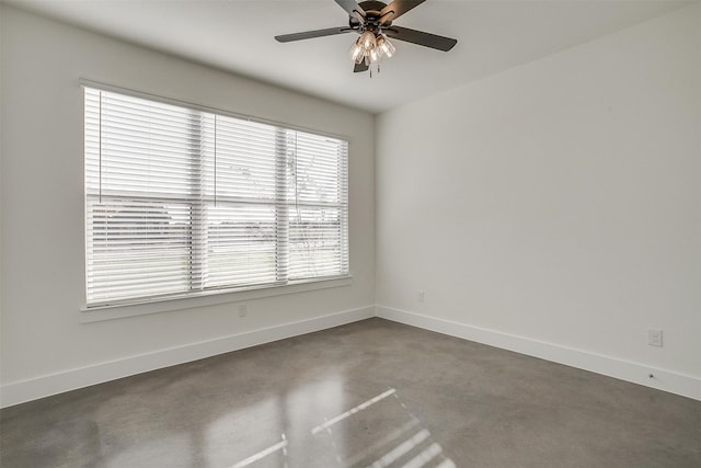 spare room with ceiling fan and concrete floors