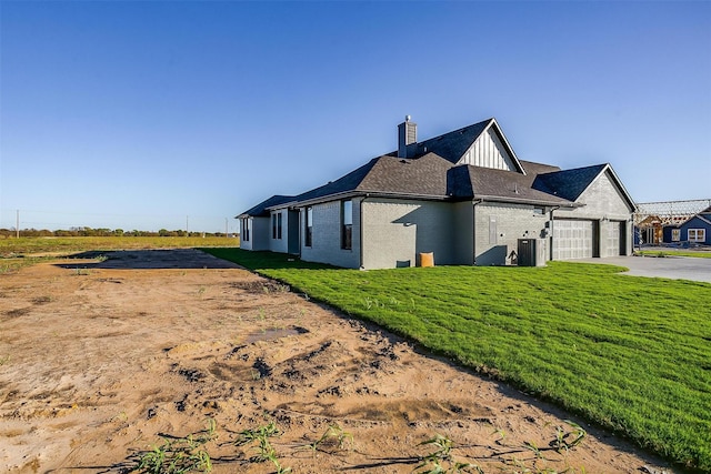 view of side of property with a garage and a lawn