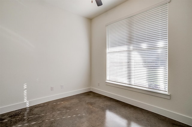 unfurnished room with ceiling fan, plenty of natural light, and concrete floors