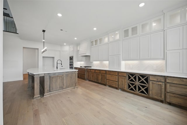 4029 Trellis Dr, Celina, TX 75078 - kitchen with light wood finished floors, a sink, stovetop, white cabinetry, and recessed lighting