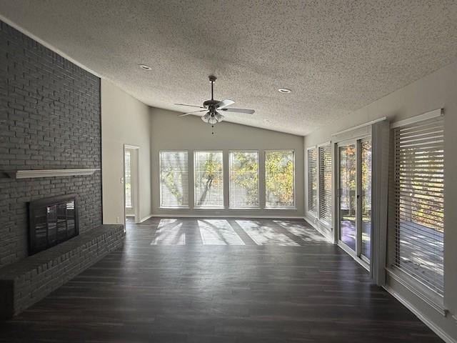 unfurnished sunroom with a fireplace, ceiling fan, and lofted ceiling