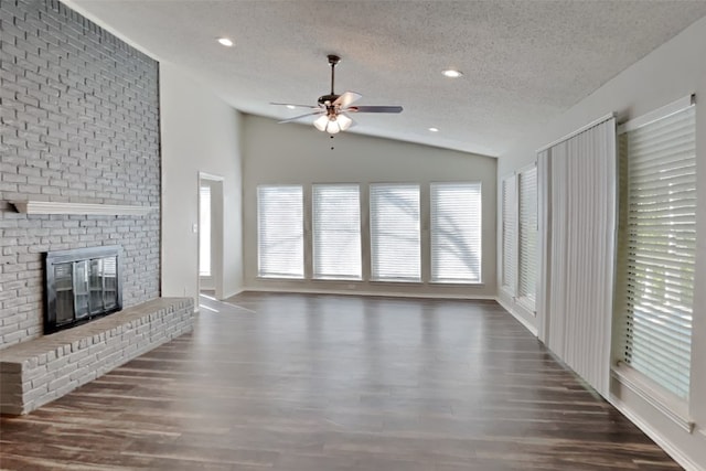 unfurnished living room featuring a fireplace, a textured ceiling, dark hardwood / wood-style flooring, and lofted ceiling