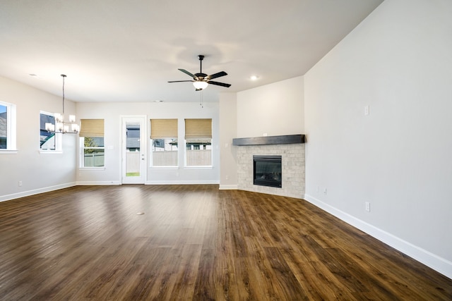 unfurnished living room featuring ceiling fan with notable chandelier and dark wood-type flooring