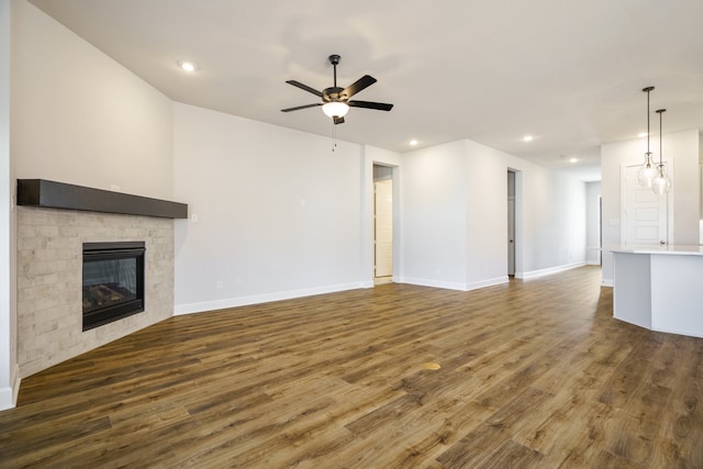 unfurnished living room featuring ceiling fan and dark hardwood / wood-style flooring