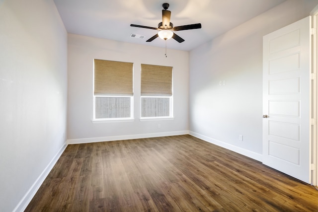 spare room featuring dark wood-type flooring and ceiling fan