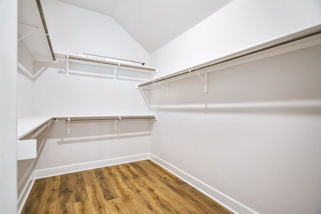 carpeted spare room with ceiling fan and vaulted ceiling