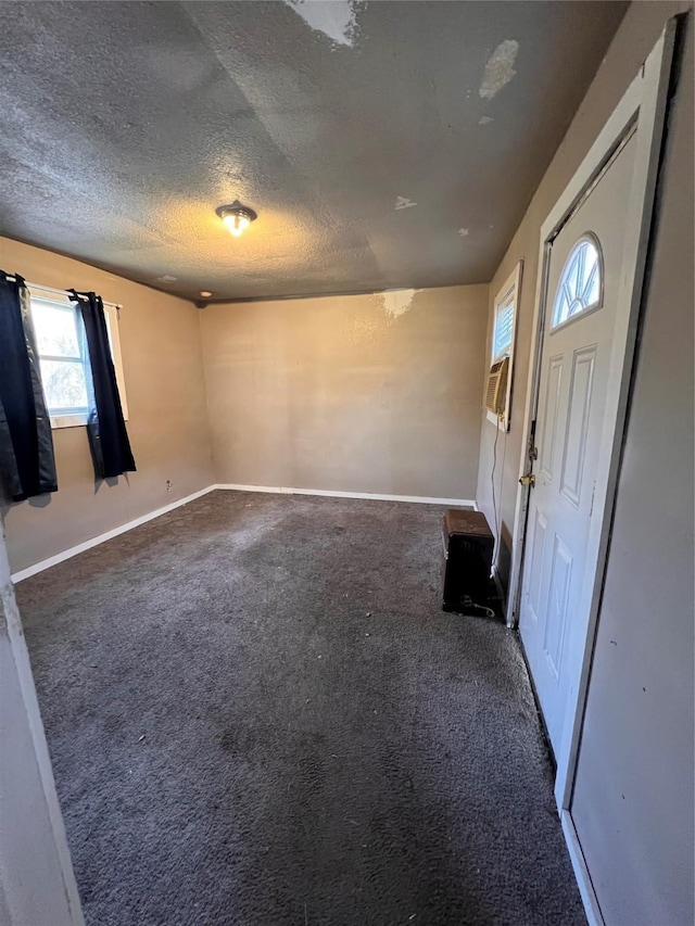 entrance foyer featuring a textured ceiling and dark carpet