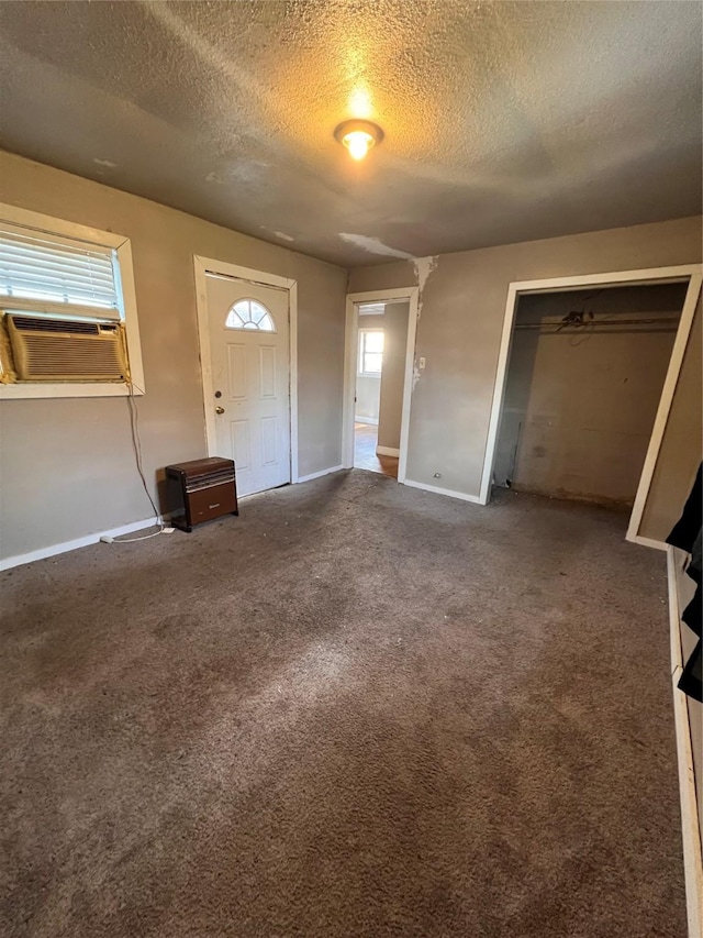 carpeted entryway with cooling unit and a textured ceiling