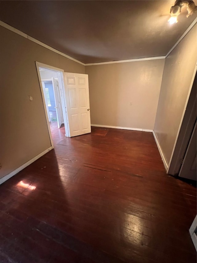 spare room featuring ornamental molding and dark hardwood / wood-style floors