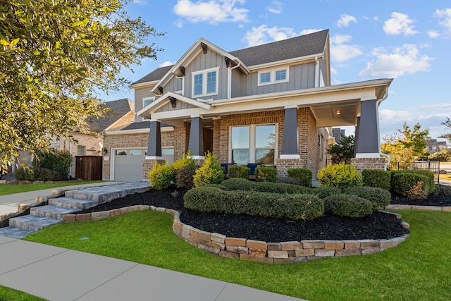 craftsman-style house featuring covered porch, a garage, and a front yard