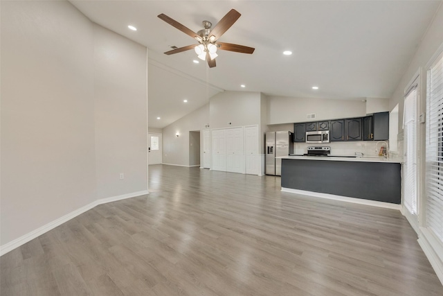 unfurnished living room featuring ceiling fan, light hardwood / wood-style flooring, high vaulted ceiling, and sink