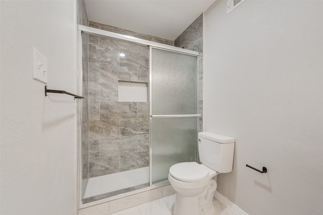 bathroom with a shower with shower door and toilet