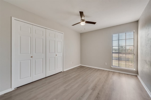 unfurnished bedroom featuring a closet, ceiling fan, and light wood-type flooring