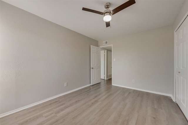 unfurnished bedroom featuring ceiling fan, light wood-type flooring, and a closet