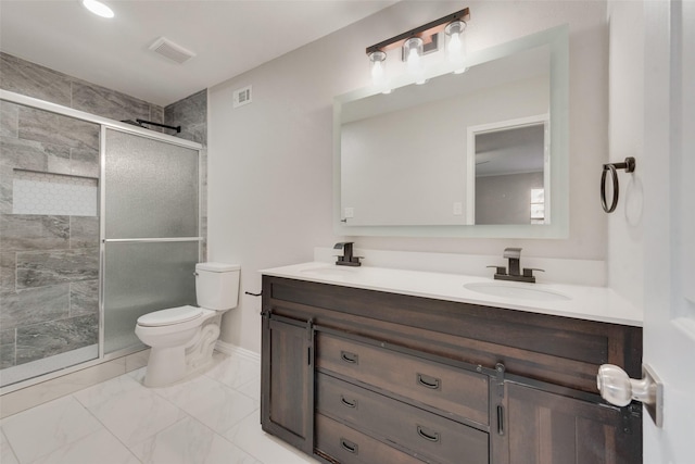 bathroom with toilet, vanity, and a shower with shower door