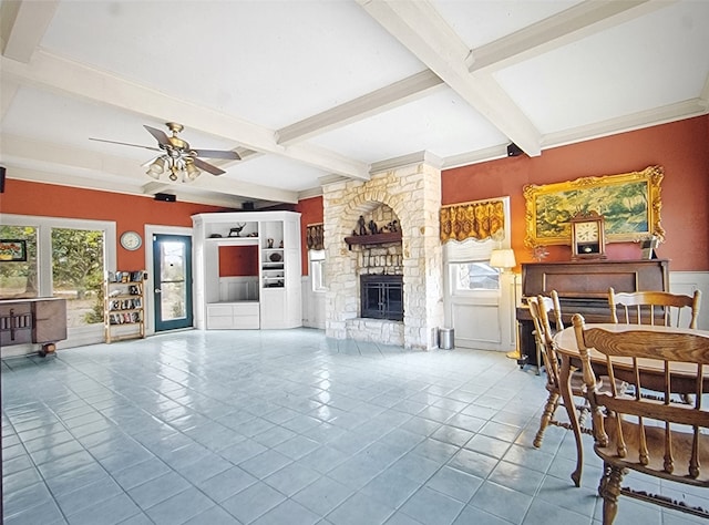 tiled living room featuring a stone fireplace, a wealth of natural light, and beamed ceiling