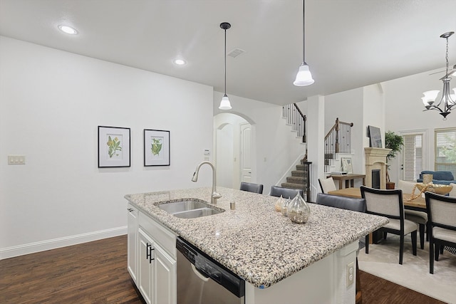 kitchen featuring white cabinetry, sink, decorative light fixtures, and dishwasher