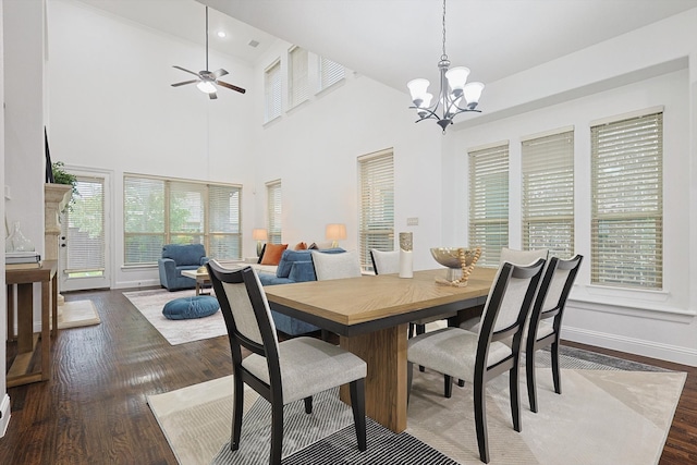 dining room featuring a towering ceiling, hardwood / wood-style flooring, and ceiling fan with notable chandelier