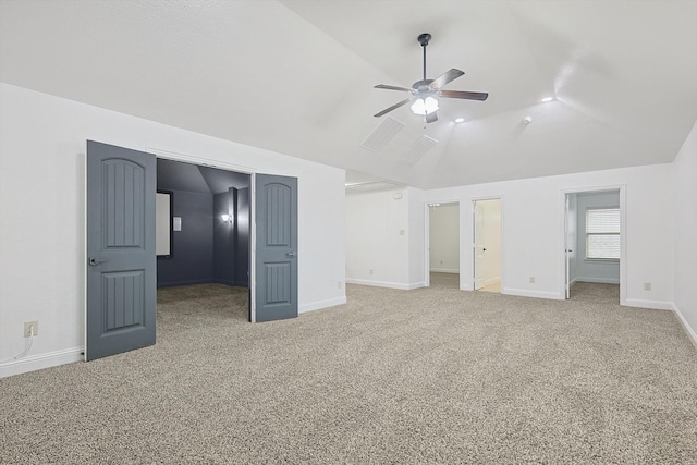 unfurnished bedroom featuring carpet flooring, ensuite bathroom, ceiling fan, and vaulted ceiling