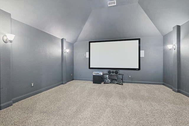 carpeted cinema room featuring vaulted ceiling