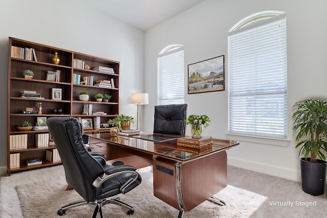 carpeted home office featuring lofted ceiling