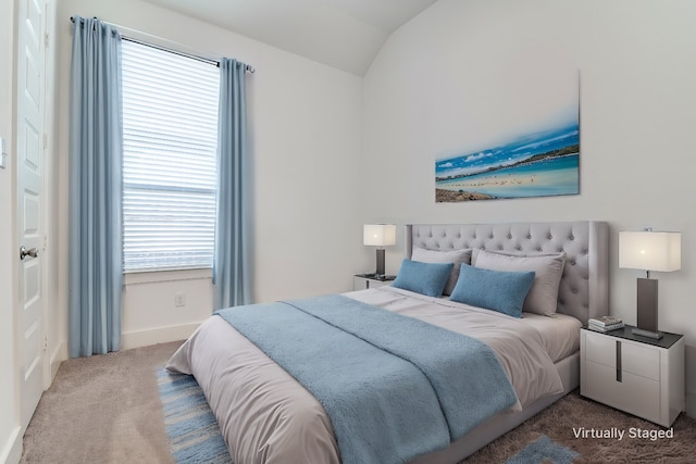 bedroom featuring multiple windows, lofted ceiling, and carpet floors