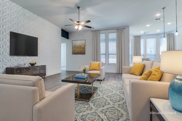 living room with wood-type flooring and ceiling fan