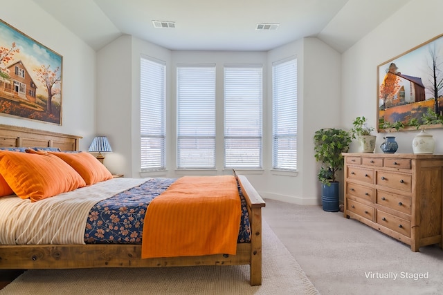 carpeted bedroom with multiple windows and lofted ceiling