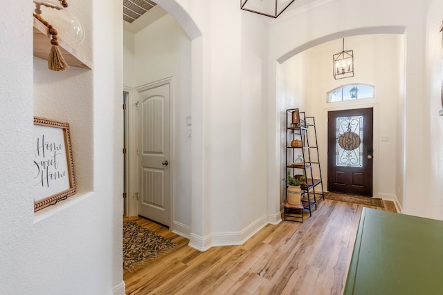 foyer with light wood-type flooring and a notable chandelier