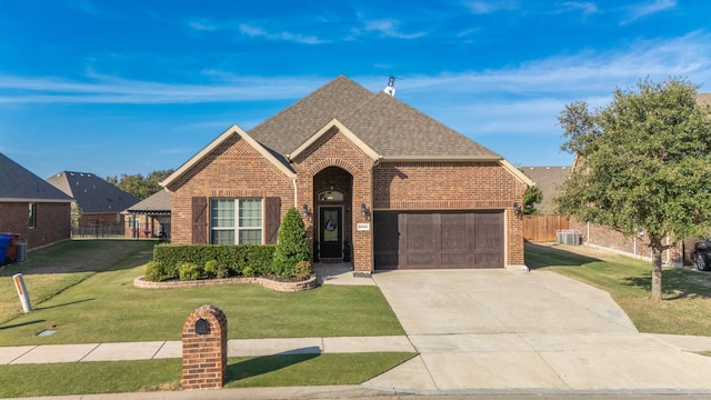 view of front of house with central AC, a front lawn, and a garage