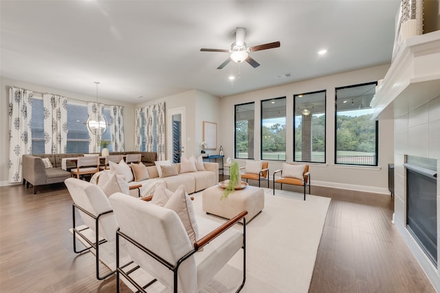 living room featuring dark hardwood / wood-style floors and ceiling fan with notable chandelier