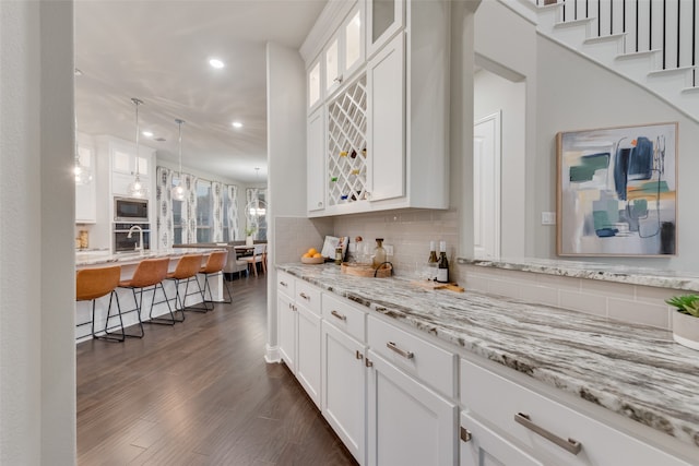 kitchen featuring white cabinets, dark hardwood / wood-style flooring, decorative backsplash, and stainless steel appliances