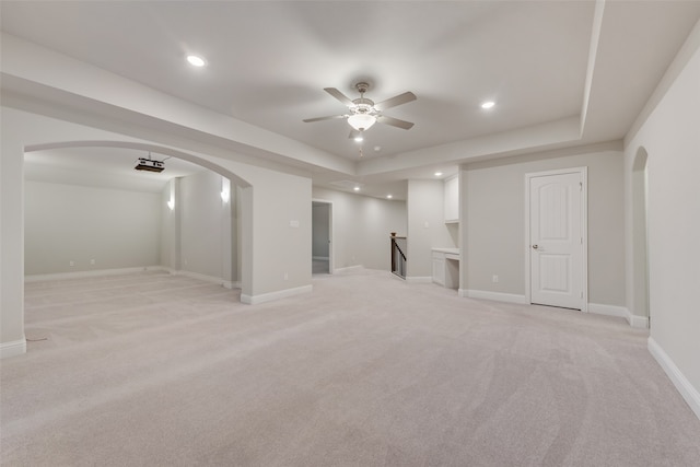 basement with ceiling fan and light carpet