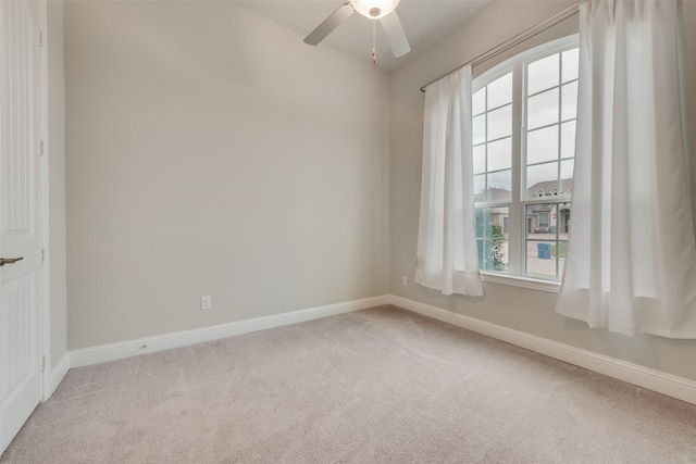 carpeted empty room with a wealth of natural light and ceiling fan