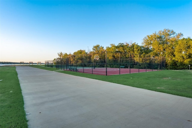 exterior space with tennis court and a lawn